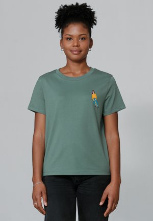 Green cotton t-shirt with a relaxed fit, short sleeves, and a small colorful graphic print on the chest.