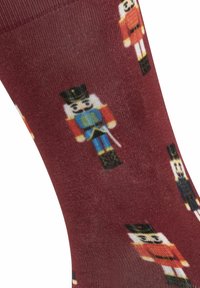 Burgunderfarbene Socken mit bunten Nussknacker-Soldatenmustern, mit glatter Textur und mittellanger Länge bis zur Wade.