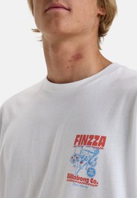 Witte katoenen t-shirt met een kleurrijke grafische print van een pizza karakter en de tekst "FINZZA" van Billabong. Ronde halslijn, korte mouwen.