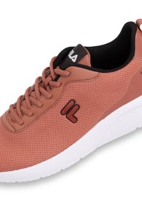 Rosafärgad mesh-sneaker med svart foder, vit sula och en glansig logotyp. Har runda snören och texturerade detaljer.