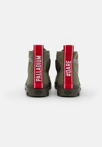 Stivali alla caviglia in tela verde con doppio inserto rosso e bianco sul tallone; presenta logo in rilievo e suola in gomma testurizzata.