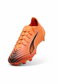 Scarpa da calcio arancione con un design testurizzato in gradiente che transita al nero nella punta. Presenta lacci standard e tacchetti in gomma stampata.
