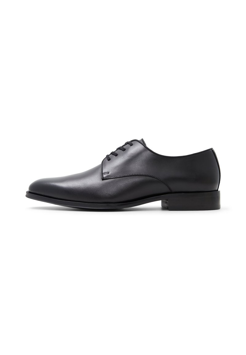 Scarpa da uomo nera in pelle con una forma slanciata, design minimalista, quattro occhielli per i lacci e un tacco basso e piatto. Texture liscia.