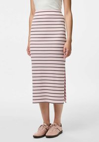 Rozā svītraina midi svārku ar horizontālām brūnām svītrām, sānu šķiršanās un mīkstu audumu. Apvienots ar gaiši rozā sporta apaviem.