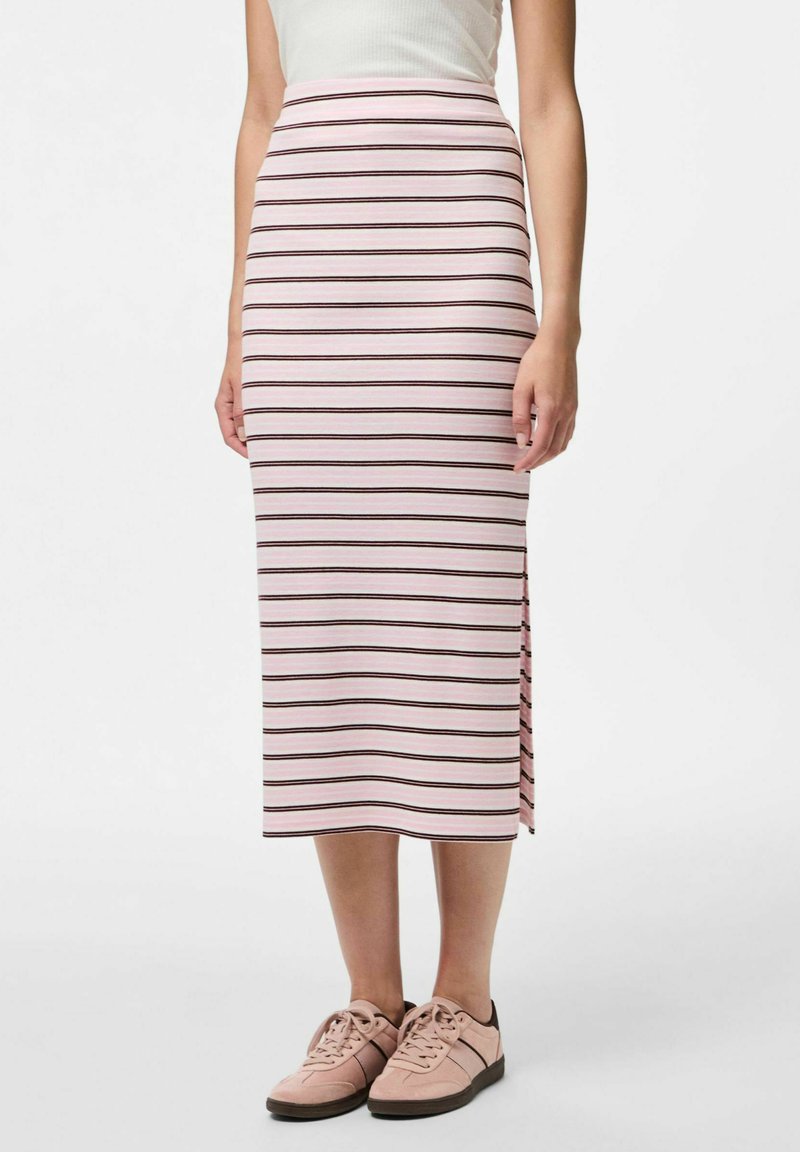 Rozā svītraina midi svārku ar horizontālām brūnām svītrām, sānu šķiršanās un mīkstu audumu. Apvienots ar gaiši rozā sporta apaviem.