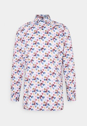 Chemise à manches longues boutonnée avec col, présentant un motif floral dense en rouge, bleu, jaune et vert sur fond blanc.