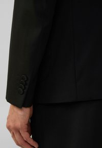 Schwarze Anzugjackenärmel mit vier schwarzen Knöpfen am Bund. Taillierte Passform mit glatter Textur und klaren Linien, die die Nähdetails zeigen.