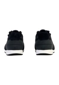 Scarpe atletiche nere con tessuto liscio e dettagli in suede, dotate di una intersuola bianca e suola in gomma, viste dal retro.
