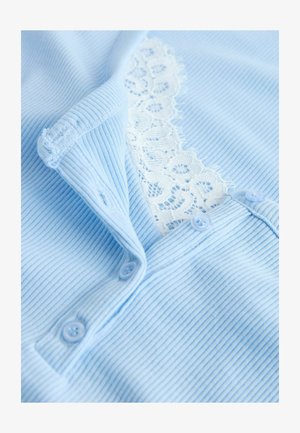 Svetlomodrá rebrovaná látka s gombíkovým pásom a bielou kvetinovou čipkou pod gombíkmi.