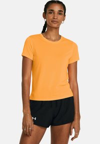 Camiseta atlética corta de manga naranja, hecha de un tejido suave, con cuello redondo y diseño ajustado, combinada con pantalones cortos atléticos negros.
