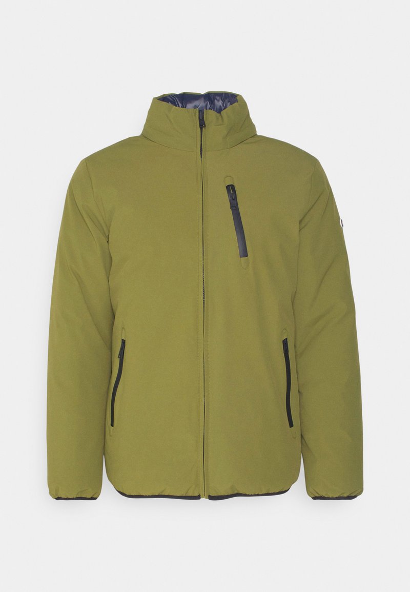 Chaqueta acolchada de color verde oliva con cierre frontal, cuello alto y bolsillos con cremallera en negro. Presenta una textura suave y acentos en negro contrastantes.