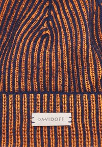 Knitted beanie hat in orange and navy with vertical stripes. Features a textured surface and a tag labeled "DAVIDOFF."
