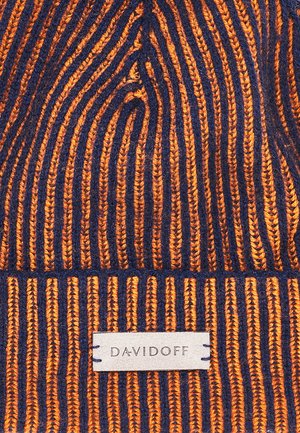 Knitted beanie hat in orange and navy with vertical stripes. Features a textured surface and a tag labeled "DAVIDOFF."
