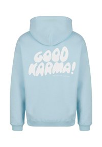 Svetlo modra kapucar s sproščenim krojem, na hrbtni strani pa so v igrivem fontu napisana beli besedilo "DOBRA KARMA!". Mehka bombažna tkanina.