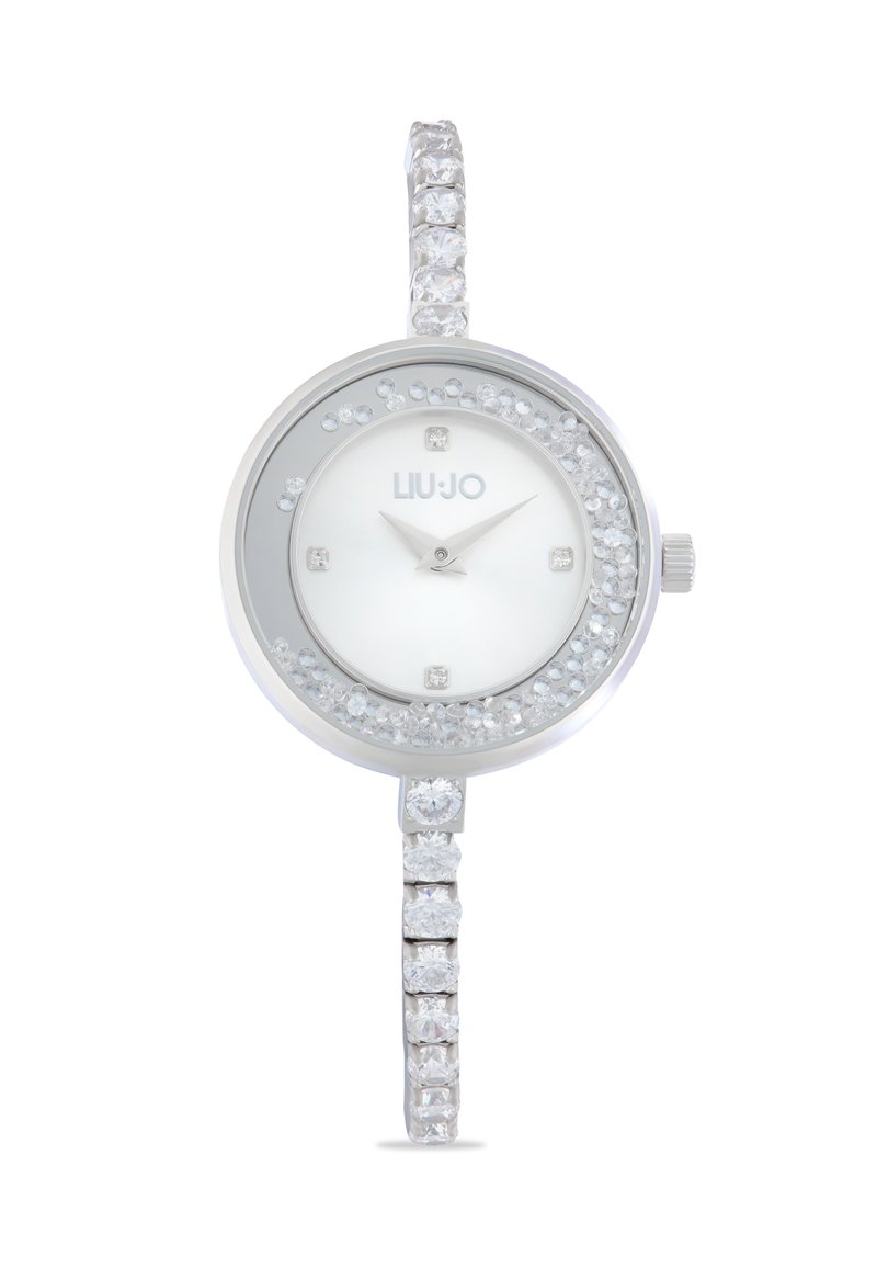 Silberne Uhr mit rundem Ziffernblatt, weißem Ziffernblatt, Kristallakzenten und einem funkelnden Armband, das mit abwechselnd quadratischen und runden Steinen verziert ist.