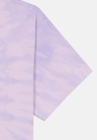 Lühikeste varrukatega tie-dye t-särk helesinises toonis, millel on pehme puuvillane tekstuur ja kanga sees õrnad mustrivariaatsioonid.