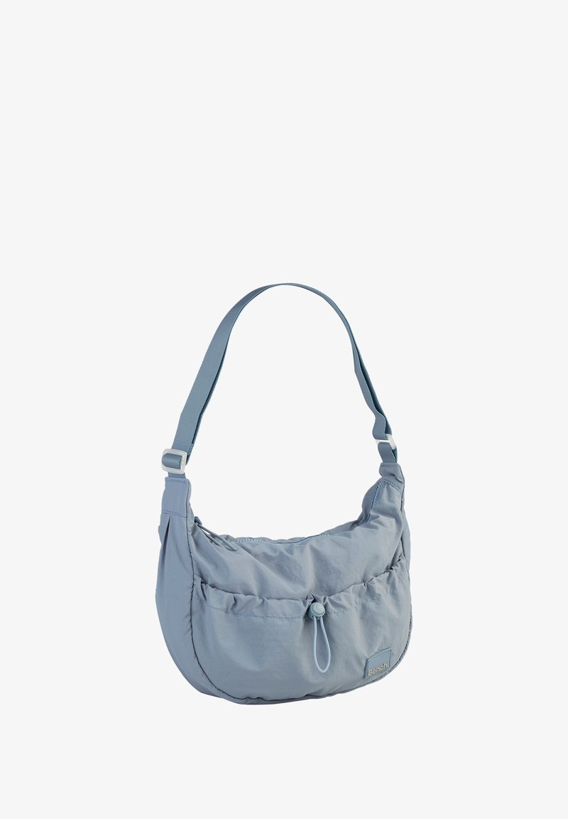 Lichtblauwe nylon schoudertas met een gebogen vorm, geplooide voorkant, verstelbare band en logo-accent. Beschikt over een centrale knoopsluiting.