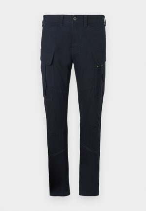 Cargo pants in dark navy fabric with multiple pockets, including side cargo pockets, and visible stitching details. Slim-fit design.