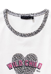 Camiseta de algodón blanca con cuello de estampado de leopardo. Presenta un diseño de corazón bordado con "WILD CHILD" en letras grandes de color rosa.