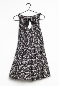 Black lace dress with floral pattern, featuring a keyhole back, pleated skirt, and a round neckline, hanging from a black hanger.