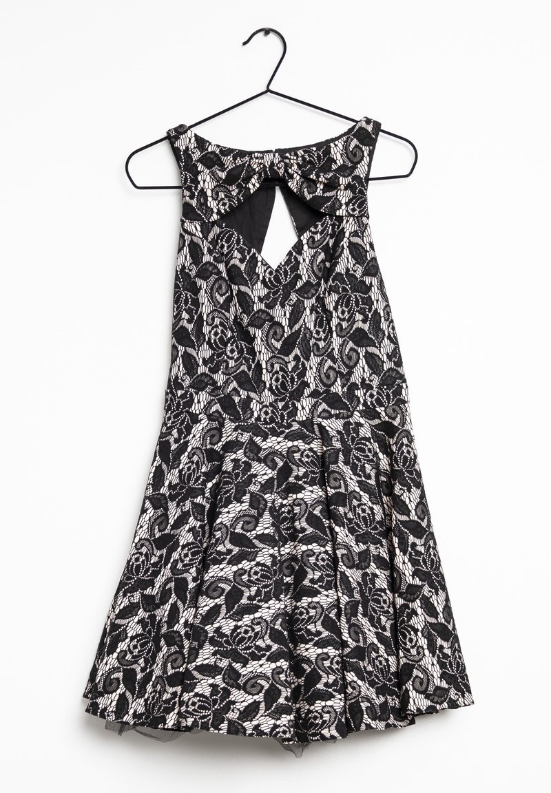 Black lace dress with floral pattern, featuring a keyhole back, pleated skirt, and a round neckline, hanging from a black hanger.