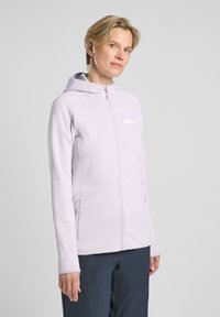 Veste zipée de couleur lavande clair au design ajusté, texture douce, capuche et poches latérales. Présente un petit logo sur la poitrine.