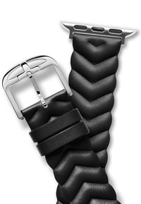 Correa de reloj de cuero negro con un patrón de chevron, que presenta una hebilla de metal plateado y un hardware de sujeción elegante. Diseño texturizado y flexible.
