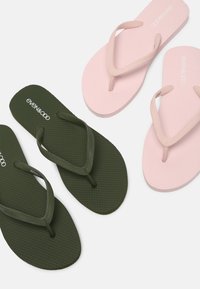 Grønne og rosa flip-flops med teksturerte såler, med smale stropper. Det grønne paret har en mørkegrønn såle, mens det rosa har en lysere nyanse.