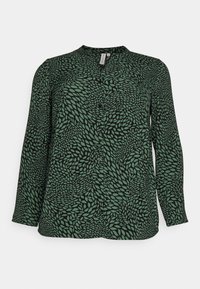 Blusa verde a maniche lunghe con un motivo fogliare nero, presenta una chiusura frontale con bottoni e un collo rotondo, realizzata in un tessuto liscio.
