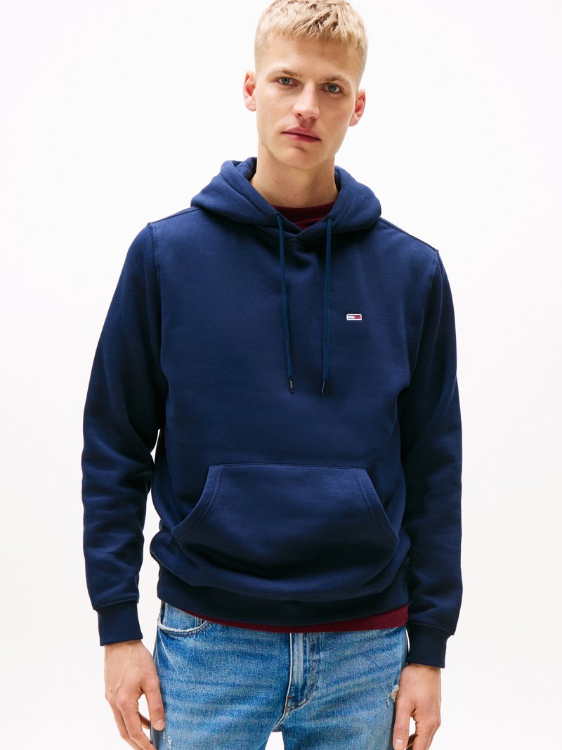 Navy hoodie made of cotton blend fabric, featuring a front kangaroo pocket and drawstring hood. Small logo on the chest, ribbed cuffs.