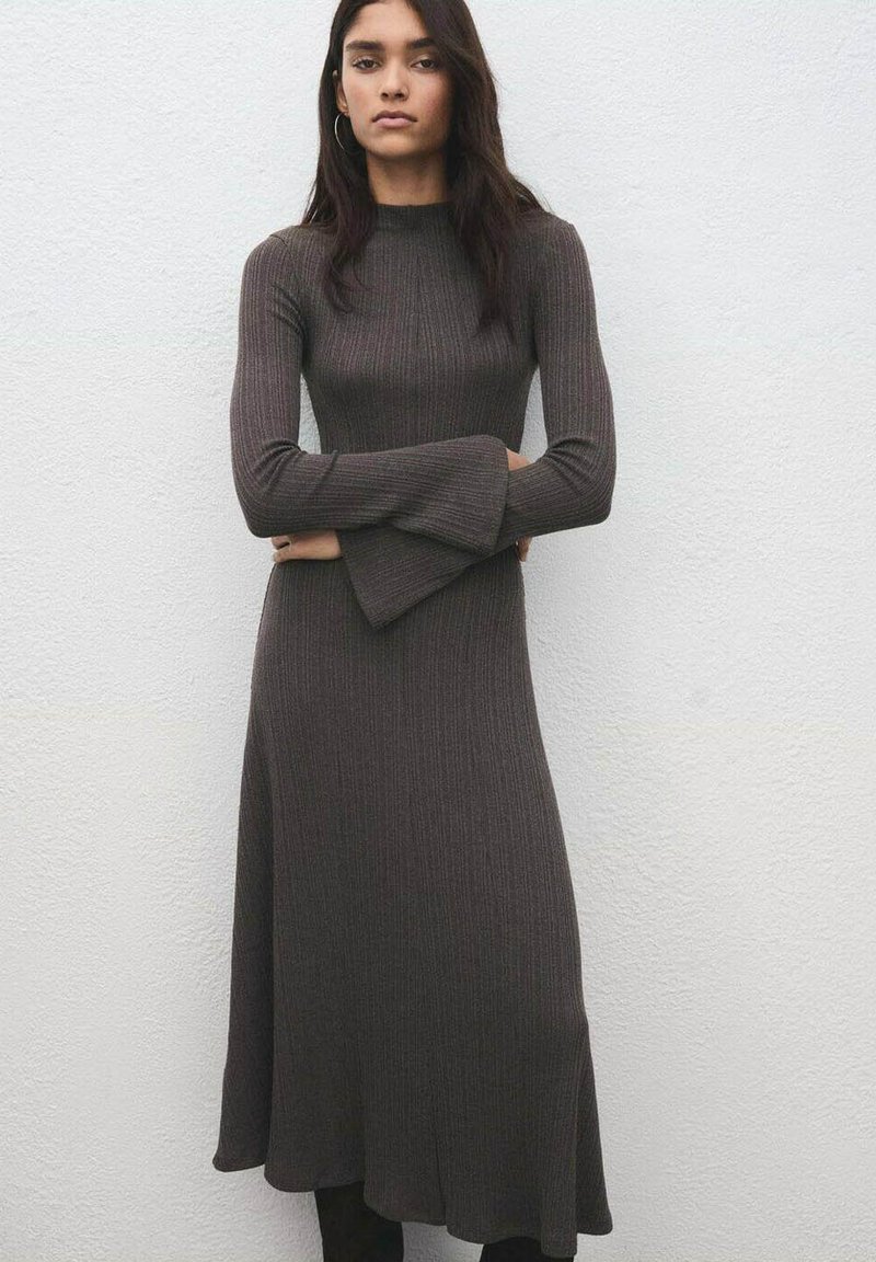 Vestido de manga larga con textura acanalada en color marrón oscuro. Presenta un top ajustado con mangas acampanadas y una falda fluida de corte en línea A.