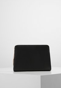 Borsa nera con finitura testurizzata, forma rettangolare e chiusura con zip, caratterizzata da hardware in tonalità oro su un lato.