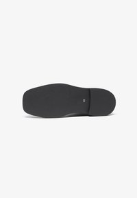 Suela de zapato negra de goma con un agarre texturizado y bordes ligeramente redondeados. Presenta la marca de tamaño "45" cerca del talón. Superficie plana y suave.