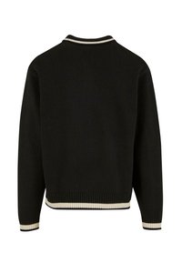 Černý svetr s žebrovaným lemem a manžetami, který má kontrastní bílý pruh na límci. Hladká textura a volný střih.