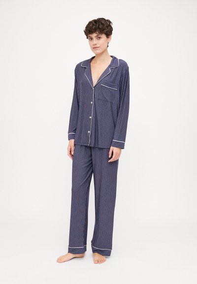 Navy striped pajama set featuring long sleeves, a button-up shirt with a pocket, and matching wide-leg pants with contrasting cuffs.
