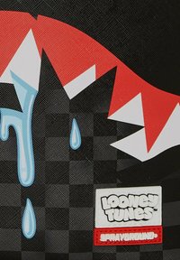 Zaino nero e rosso con un design di goccia d'acqua, motivo a scacchi e loghi "Looney Tunes" e "Sprayground."