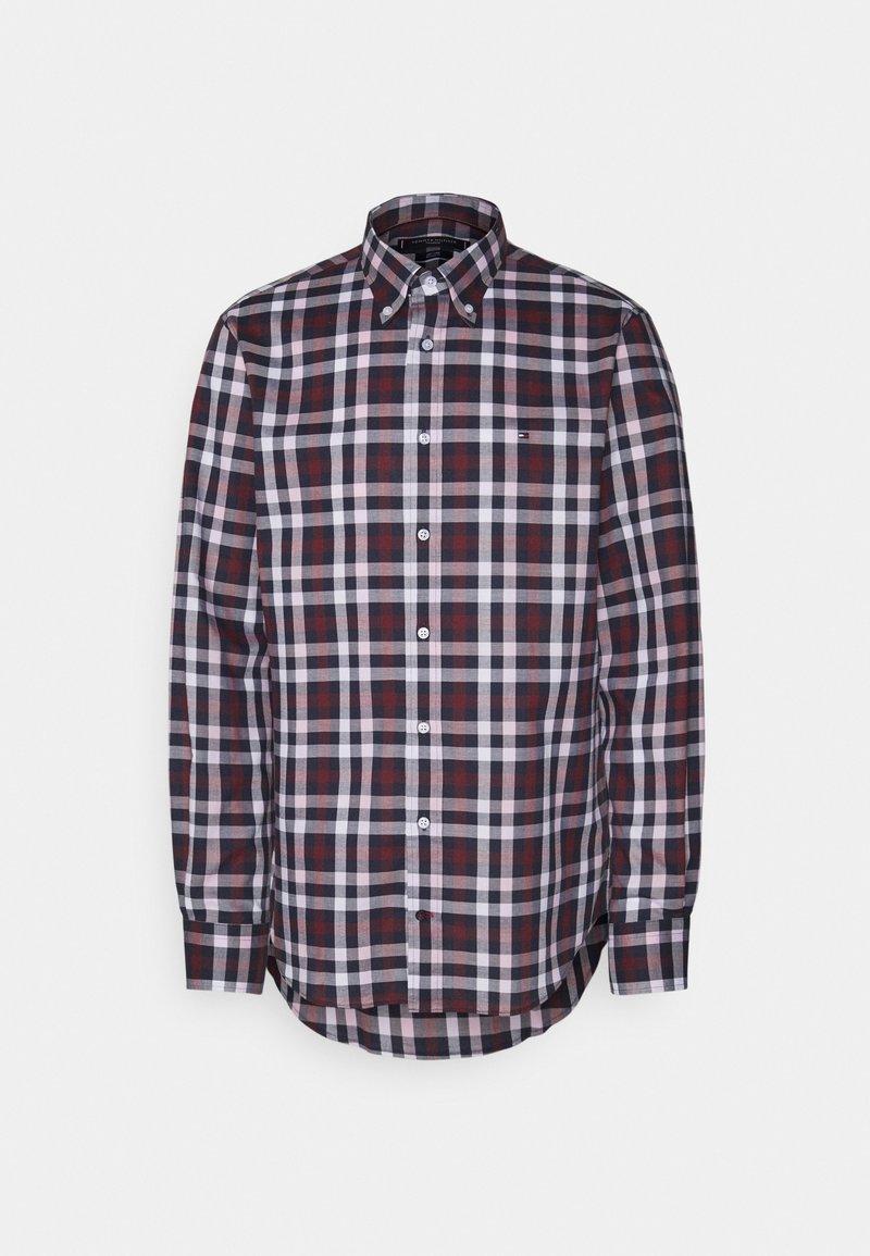 La camicia a quadri presenta una combinazione di colori blu navy, rosso e bianco, colletto con bottoni, maniche lunghe e un orlo curvo. Realizzata in un tessuto dalla superficie liscia.