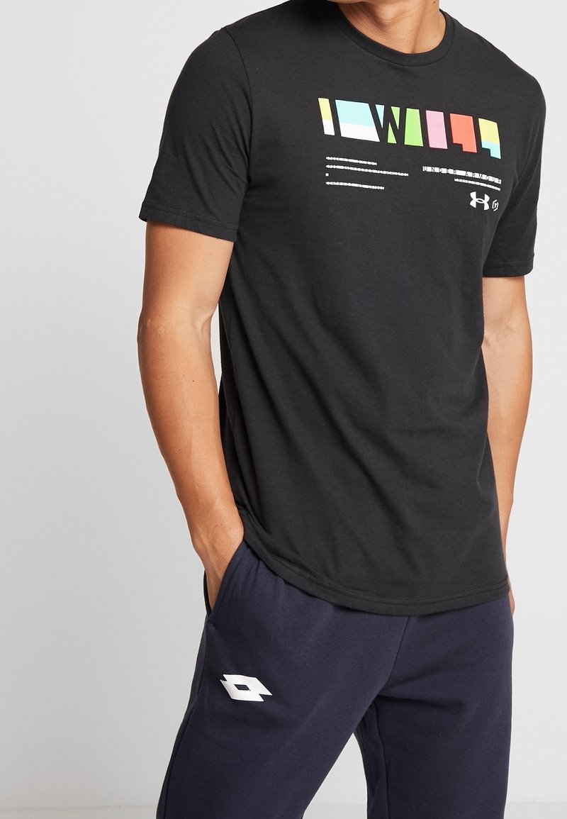 Svart t-shirt med kort ärm som har en färgglad grafisk design på framsidan. Materialet verkar vara mjukt med en klassisk rund hals.