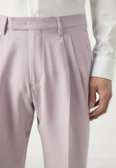 Helle lila maßgeschneiderte Hose mit glatter Textur, ausgestattet mit Falten, flachem Bund und Seitentaschen, kombiniert mit einem weißen Hemd.