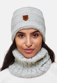 Gray knitted beanie with a textured pattern and faux fur lining, featuring a leather emblem on the front, paired with a matching cowl neck scarf.