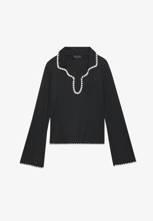 Black long-sleeve top featuring a scalloped white trim along the neckline and cuffs, made of textured fabric with a cropped design.