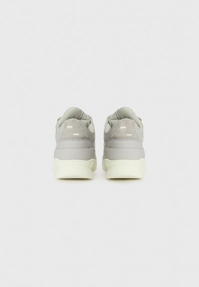 Gray suede and leather low-top sneakers with a textured heel, featuring minimalistic white accents and a light-colored sole.