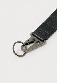 Sorte lædernøglesnor med tekstureret overflade, udstyret med en metalclips og ringbeslag i en mørk finish.