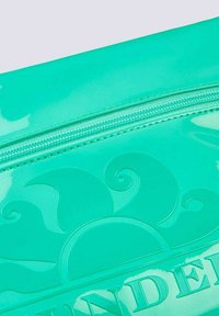 Una borsa teal lucida con un design a onde in rilievo e una chiusura lampo visibile sulla parte superiore. Texture liscia con finitura lucida.