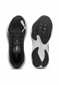 Schwarze Sportschuhe mit einem atmungsaktiven Mesh-Obermaterial, schwarzen Schnürsenkeln und einer weißen Sohle, die ein strukturiertes Traktionsmuster und Logodetails aufweist.