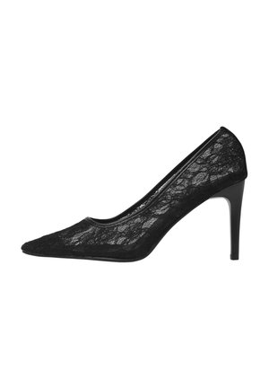 Scarpa nera in pizzo con tacco alto e punta affusolata; presenta un profilo elegante con finiture nere lucide e un tacco di 10 cm.