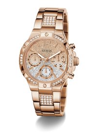 Montre Guess en or rose avec cadran scintillant, trois sous-cadrans, accents en cristal sur la lunette et le bracelet, et bracelet en métal.