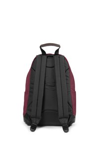 Svart och vinröd ryggsäck med vadderade axelremmar, ett handtag ovanpå och en slät yta. Har en minimalistisk design och ingen synlig hårdvara.