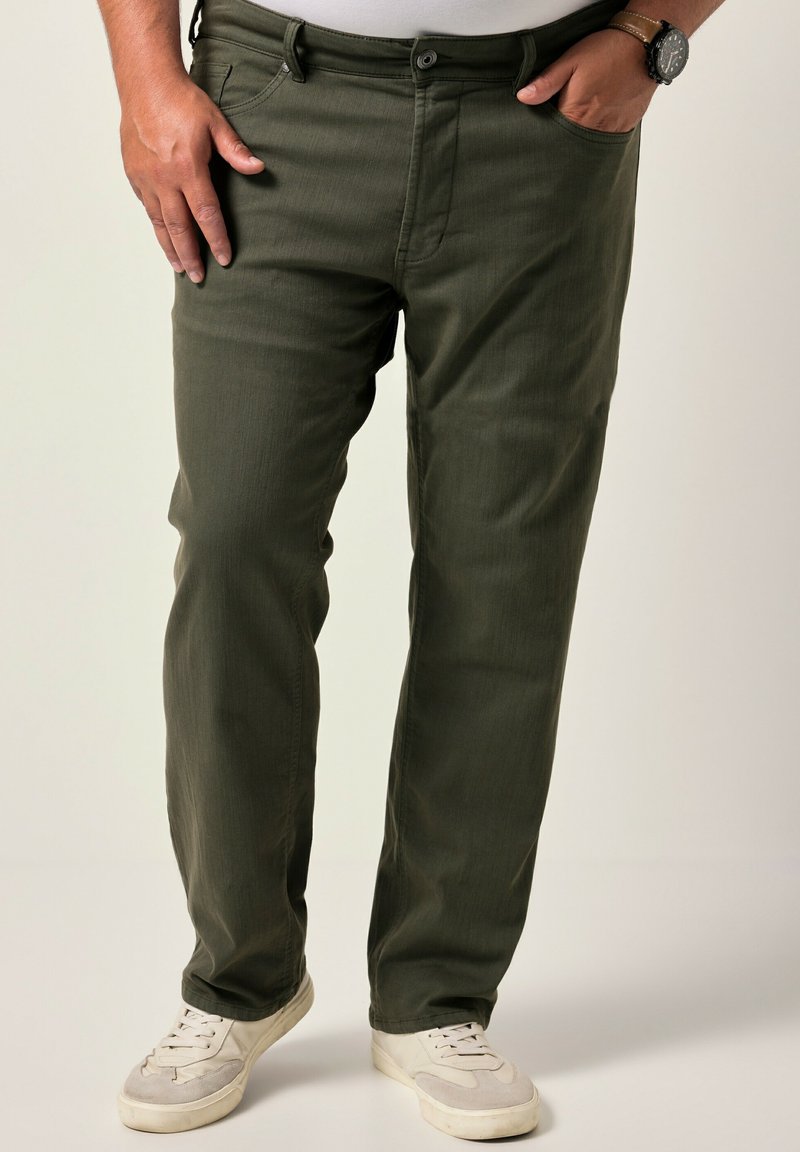 Pantalones verde oliva hechos de una tela suave y texturizada con un diseño de pierna recta y cinco bolsillos, combinados con zapatillas blancas.