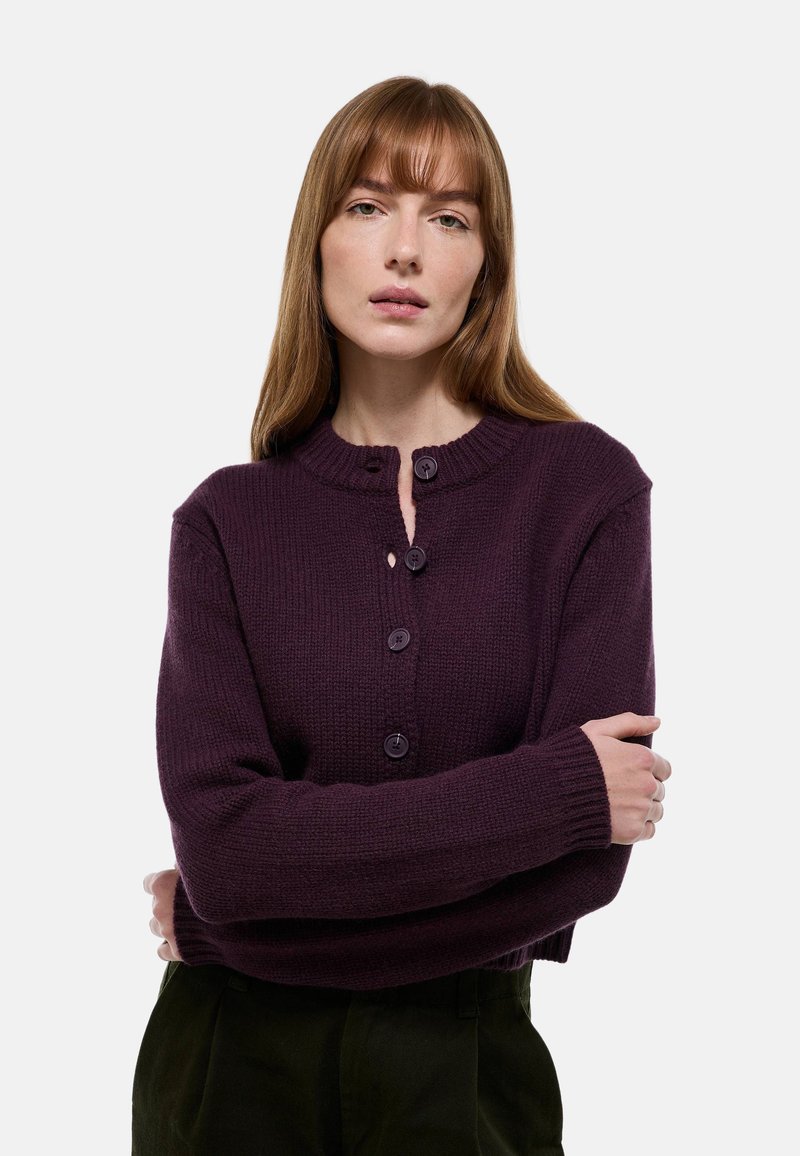 Cardigan en tricot violet doté d'un col rond, de cinq boutons, de poignets côtelés et d'une coupe légèrement cintrée.